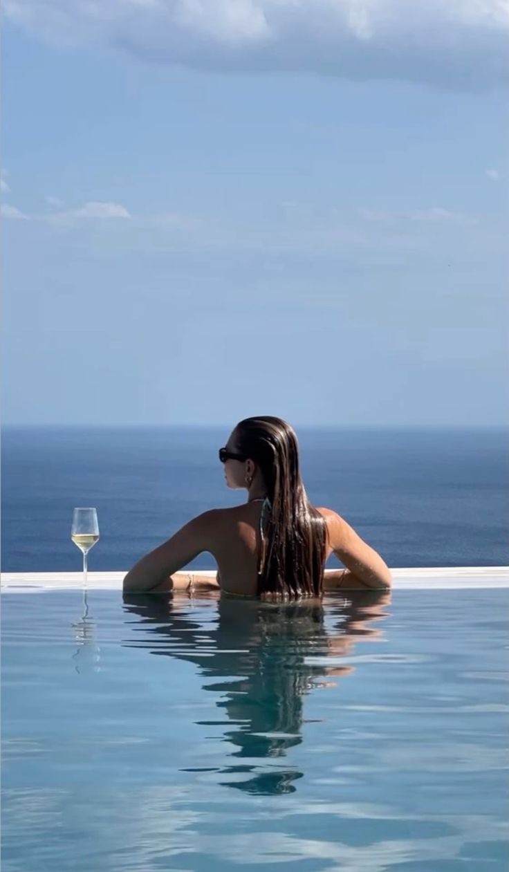 Woman overlooking the ocean from an infinity pool at a luxury property